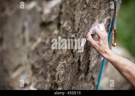 Rock Climber's main agrippant petite attente sur falaise naturelle, de l'accent Banque D'Images