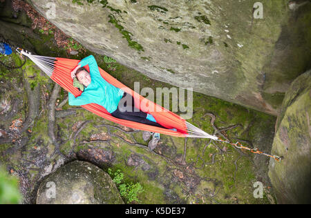 Cheerful young woman relaxing in hammock près de Falaise, vue de dessus Banque D'Images