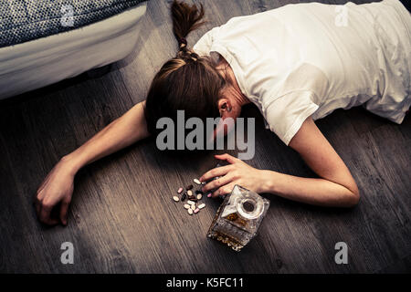 Ivre ou intoxiqué jeune femme avec bouteille d'alcool et des pilules, whisky et les drogues, la toxicomanie Banque D'Images