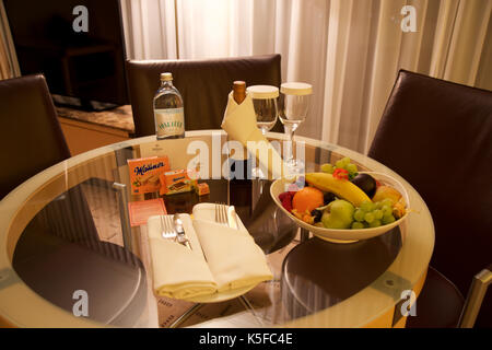 Vienne, Autriche - avril 28th, 2017 : soirée romantique avec bouteille de vin rouge, de sucreries et de fruits dans la chambre d'hôtel de luxe sur une table avec trois chaises en cuir, hilton suite penthouse Banque D'Images