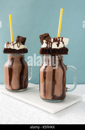 Deux freakshakes au chocolat maison, des milkshakes, des brownies, sauce au chocolat et la crème fouettée. Banque D'Images