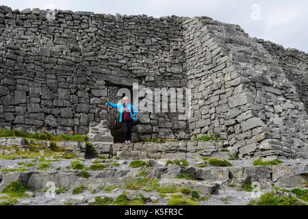 Un touriste se dresse à l'entrée de Dun Aonghasa, un fort de pierre préhistoriques sur l'île de Inishmore dans le groupe Aran, comté de Galway, en République d'Irlande Banque D'Images