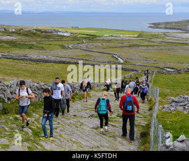 Les touristes sur sentier menant à Dun Aonghasa, un fort de pierre préhistoriques, sur l'île de Inishmore dans le groupe Aran, comté de Galway, en République d'Irlande Banque D'Images