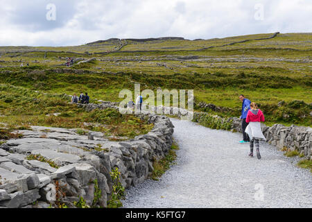 Les touristes sur sentier menant à Dun Aonghasa, un fort de pierre préhistoriques, sur l'île de Inishmore dans le groupe Aran, comté de Galway, en République d'Irlande Banque D'Images