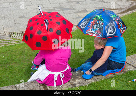 Swanage, Dorset, UK. Sep 9, 2017. Météo France : forte pluie et tonnerre à Swanage. Des gens assis sur mur sous les parasols en essayant de garder au sec. Credit : Carolyn Jenkins/Alamy Live News Banque D'Images