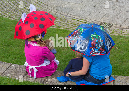 Swanage, Dorset, UK. Sep 9, 2017. Météo France : forte pluie et tonnerre à Swanage. Des gens assis sur mur sous les parasols en essayant de garder au sec. Credit : Carolyn Jenkins/Alamy Live News Banque D'Images