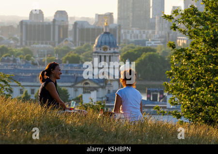 Deux jeunes femmes connaissant journée ensoleillée à Greenwich Park à Londres, Angleterre, Royaume-Uni, UK Banque D'Images