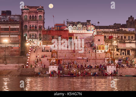 Une foule de personnes se baignant dans le Gange avant que le soleil se lève sur le jour d'après dev diwali. la lune est dans la phase "super lune". Banque D'Images