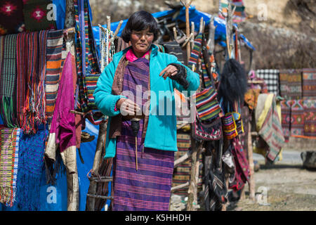 Dame spinning poil de yack tout en tendant l'artisanat et de souvenirs se situe à pele la col de montagne, le Bhoutan central Banque D'Images