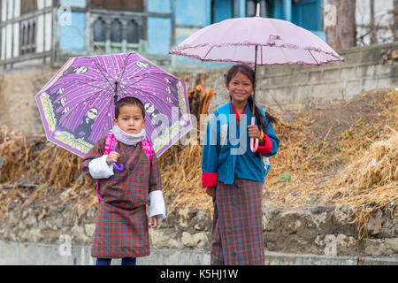 Les écoliers en costume traditionnel avec parasols, Thimphu, Bhoutan de l'ouest Banque D'Images