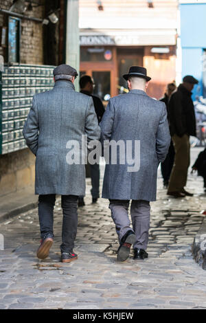 Deux hommes en manteaux et chapeaux élégant sortir de passage lhomme de la rue de Charonne dans le 11ème, Paris. Banque D'Images