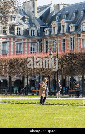 Le soleil brille, les gens à la place des Vosges dans le marais, Paris Banque D'Images