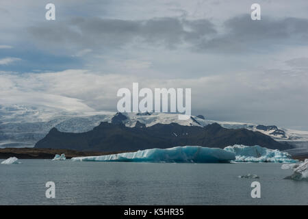 Les icebergs flottant dans une lagune glaciaire en face de la fonte des glaciers Banque D'Images