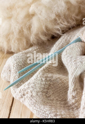 Bonneterie faits de laine naturelle, des aiguilles à tricoter et de la laine sur le vieux fond de bois Banque D'Images