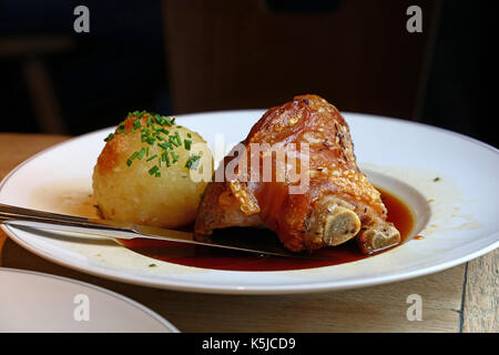 Rôti de porc succulent jarret avant ou avec fusée et ciboulette boulettes bavaroises dans la plaque sur la table, Close up, low angle view Banque D'Images