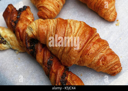 Des golden brown croissants français et feuilletée pâte feuilletée sur du papier blanc parchemin dans l'affichage de détail boulangerie, Close up, high angle view Banque D'Images