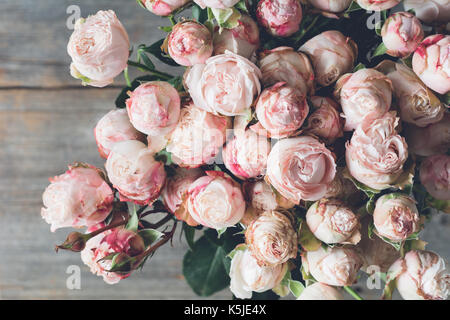 Les rosiers arbustes rose bouquet sur fond de bois. Belle shabby chic mariage bouquet de fleurs. Vue rapprochée de tonification vintage. Banque D'Images