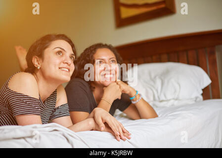 Deux jeunes laïcs womans sur bed and looking up Banque D'Images