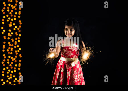 Stock photo de petite fille indienne célébrant Diwali avec brûler sparkle ou phoolzadi fulzadi ou diwali Diwali sur la nuit avec éclairage bokeh Banque D'Images