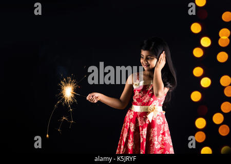 Stock photo de petite fille indienne célébrant Diwali avec brûler sparkle ou phoolzadi fulzadi ou diwali Diwali sur la nuit avec éclairage bokeh Banque D'Images