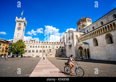 Trento, Italie, 14 août 2017 - une jeune femme aller en bicyclette au milieu de la piazza Duomo à trente. voyager en location en Italie, voyage culturel en italie Banque D'Images