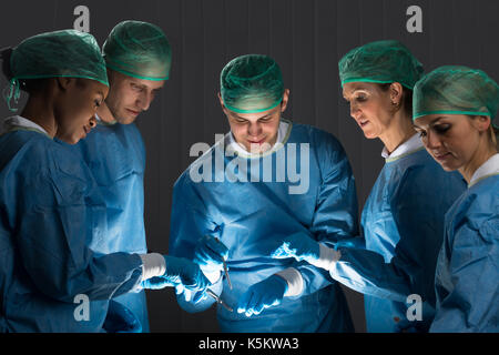 Groupe de chirurgiens en uniforme au travail en salle d'opération Banque D'Images