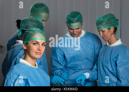 Groupe de Médecins Wearing Blue Scrubs In Operating Room Banque D'Images