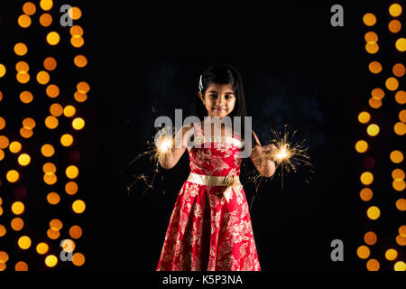 Stock photo de petite fille indienne célébrant Diwali avec brûler sparkle ou phoolzadi fulzadi ou diwali Diwali sur la nuit avec éclairage bokeh Banque D'Images