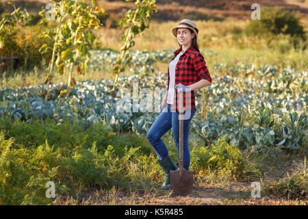 Happy woman holding spade jardinier dans le jardin. jardinage, l'agriculture, concept la récolte d'automne Banque D'Images