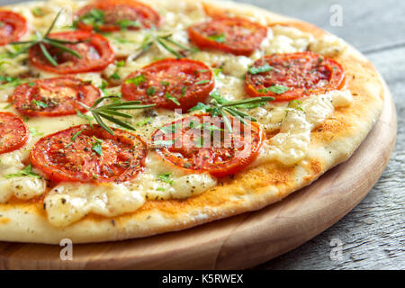 Pizza Margherita avec tomates, fromage, basilic et romarin. mince maison pizza végétarienne. Banque D'Images