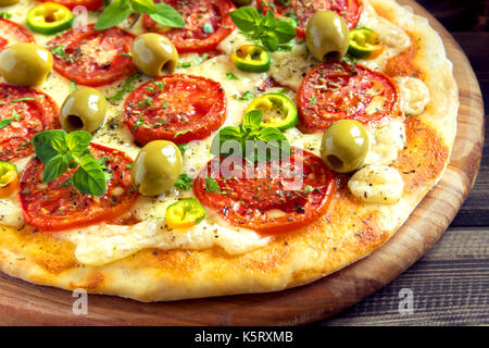 Pizza mexicain épicé avec tomates, olives et piments jalapenos. pizza végétarienne avec l'origan. Banque D'Images