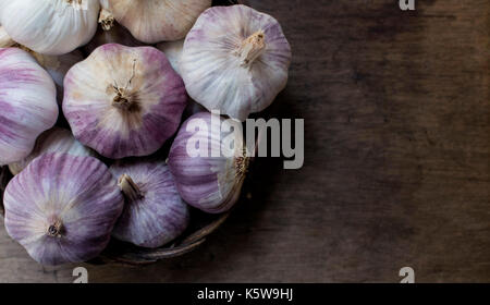 Panier plein de vigne ensemble l'ail violet, sur le dessus d'un fond de bois, avec copie espace Banque D'Images