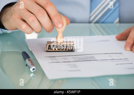 Close-up of Person's Hand Stamping sur le document Banque D'Images