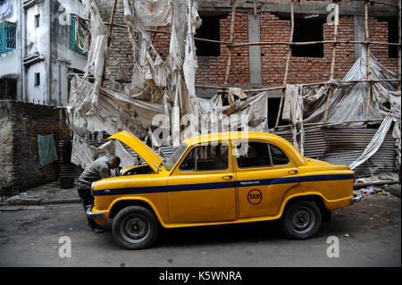 03.12.2011, Kolkata, Bengale occidental, Inde, Asie - un chauffeur de taxi a l'air sous le capot de son taxi jaune de la marque Cadillac Sedan de Kolkata. Banque D'Images