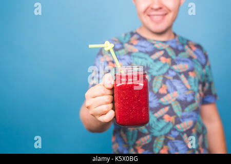 Close up of man holding smoothie détox avec paille. concept de vie sain, les gens et de l'alimentation Banque D'Images