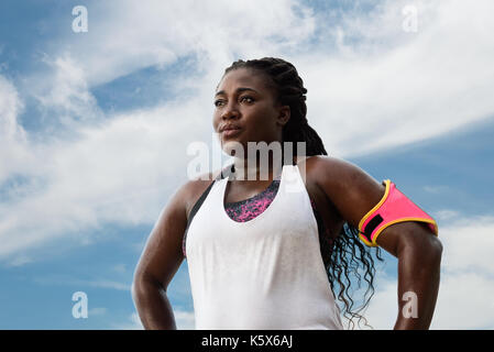 Femme africaine sportive de la transpiration après l'exercice sur l'été chaud sur fond de ciel bleu.athlète féminin après le travail. Banque D'Images