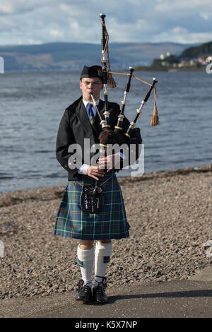 Piper écossais jouant la cornemuse sur la plage à Largs. Firth of Clyde, en Écosse, Royaume-Uni Banque D'Images