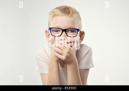 Jeune garçon enfant montre des signes geste de la main tenant le doigt sur les lèvres. Banque D'Images