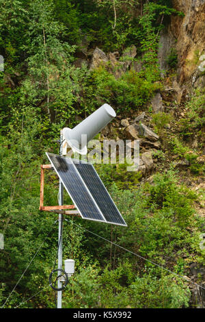 Panneau solaire powered antenne de station de communication avec l'arrière-plan de la végétation naturelle et falaise Banque D'Images