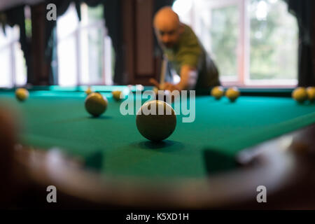 Jeune homme jouant au billard à l'intérieur. Passer du temps libre au jeu Banque D'Images