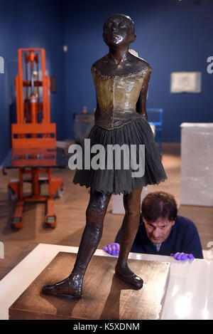 La sculpture de bronze &ocirc;Petite danseuse de quatorze ans&otilde ; par Edgar Degas est déplacé en position par collections manager nik zolman, une partie d'une nouvelle manifestation, 'Degas : une passion pour la perfection', au Fitzwilliam Museum de Cambridge. Banque D'Images