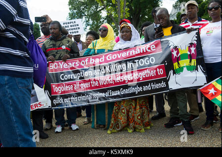 Vu un manifestant tenant une bannière à l'avant de la manifestation. Une petite foule se rassemble en face de la Maison Blanche pour protester contre le dictateur togolais Faure Gnassingbe.Avant son élection, il a été nommé par son père, le Président Gnassingbé Eyadéma, en tant que ministre de l'équipement, des Mines, des postes et télécommunications, servant de 2003 à 2005. À la suite du décès du Président Eyadéma Gnassingbé en 2005, a immédiatement été installé à la présidence avec le soutien de l'armée. Des doutes sur la légitimité constitutionnelle de la succession conduit à de lourdes pressions régionales mis sur Gnassingbé, et il les Banque D'Images