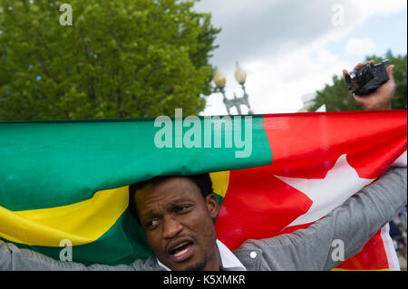 Un manifestant affiche un drapeau national du Togo pendant la manifestation. Une petite foule se rassemble en face de la Maison Blanche pour protester contre le dictateur togolais Faure Gnassingbe.Avant son élection, il a été nommé par son père, le Président Gnassingbé Eyadéma, en tant que ministre de l'équipement, des Mines, des postes et télécommunications, servant de 2003 à 2005. À la suite du décès du Président Eyadéma Gnassingbé en 2005, a immédiatement été installé à la présidence avec le soutien de l'armée. Des doutes sur la légitimité constitutionnelle de la succession conduit à de lourdes pressions régionales mis sur Gnassingbé, et par la suite, il res Banque D'Images