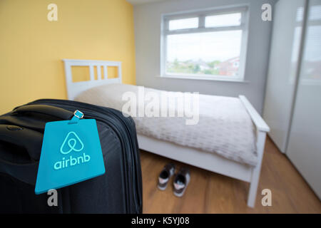 Airbnb avec étiquette d'une marque liée à une valise dans une chambre à louer dans le cadre d'un appartement Airbnb. Banque D'Images