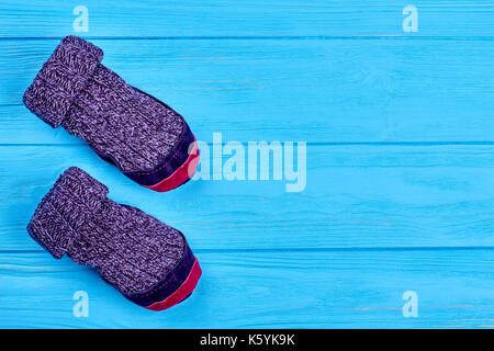 Chaussettes de laine childs, copiez l'espace. kids violet chaussettes tricotées en laine bleu sur fond de bois naturel des chaussettes en laine tricotées. pour les enfants. prix chaussons wi Banque D'Images