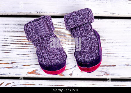 Les enfants en laine tricoté prix chaussons. childs pourpre chaud Winter socks on white background. aire narural vêtement fait main. Banque D'Images