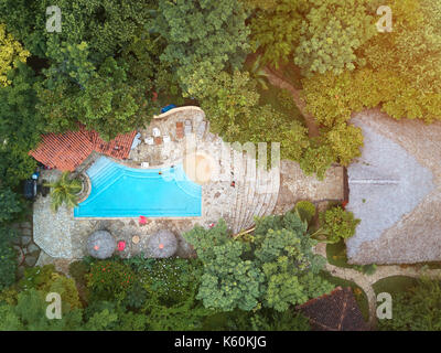 Vue aérienne sur la piscine avec de l'eau bleu autour de fond vert naturel Banque D'Images