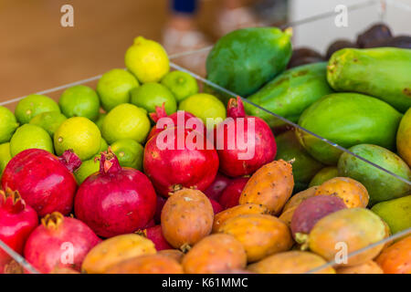 Grenades rouge, jaune citron, orange, orange figues mangues, fruits en boîtes transparentes Banque D'Images