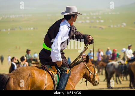 Oulan-bator, Mongolie - 12 juin 2007 : cowboy mongole en vêtements traditionnels et chapeau de cowboy riding horse parmi foule à cheval dans la steppe en t Banque D'Images