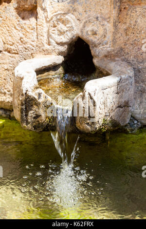 L'eau potable fraîche découlant d'une ancienne fontaine à eau à Crete Banque D'Images